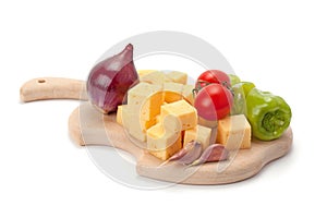 Cheese and vegetables on wooden board