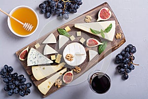 Cheeseboard with cheese brie parmesan , camembert and dorblu . Food on wooden board