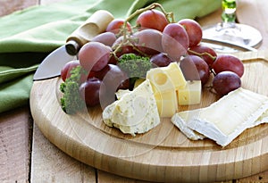 Cheeseboard with cheese and grapes photo