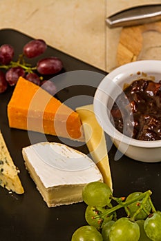 Cheeseboard platter with grapes and pickle and crackers