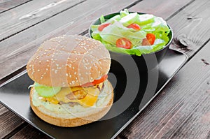 Cheeseburger with bacon and tartar sauce and garden salad