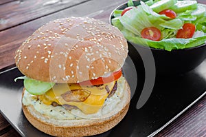 Cheeseburger with bacon and tartar sauce and garden salad