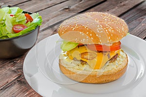 Cheeseburger with bacon and tartar sauce and garden salad