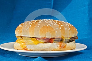 Cheeseburger on blue linen background