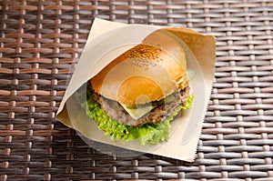 Cheeseburger with cutlet, cheese and lettuce in a paper bag. fast food takeaway