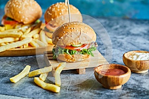 Cheeseburgers with fry potato on the wooden board