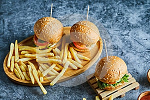 Cheeseburgers with fry potato on the wooden board