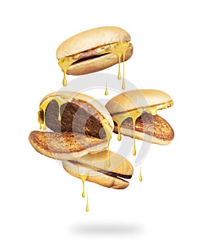 Cheeseburgers with melted cheese fall down isolated on a white background