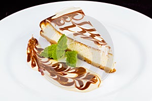 Cheesecake with chocolate topping on white plate