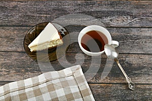 Cheesecake with coffee on a dark wooden background. view from above. A cheesecake next to it on a brown wooden background. retro