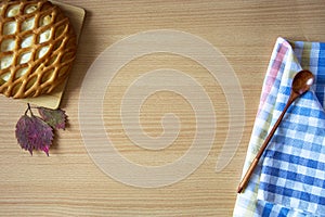 Cheesecake with cottage cheese, autumn leaves and a spoon on a wooden background. Empty space for text. Layout top view