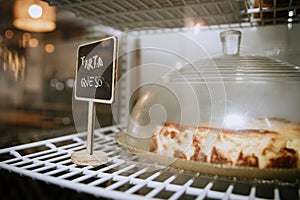 cheesecake displayed on the grill of a fridge with an indicative sign in Spanish
