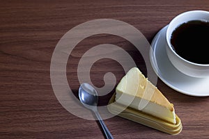 Cheesecake with hot coffee on a dark wooden table and copy space
