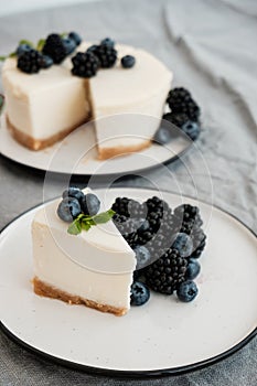 Cheesecake New York with fresh berries and a slice on a plate