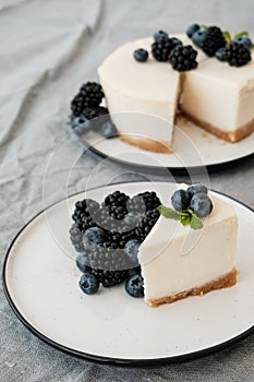 Cheesecake New York with fresh berries and a slice on a plate