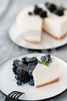 Cheesecake New York with fresh berries and a slice on a plate