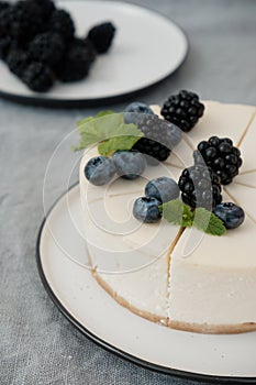 Cheesecake New York with fresh berries and a slice on a plate