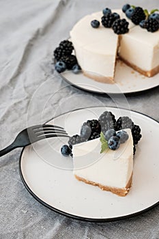 Cheesecake New York with fresh berries and a slice on a plate