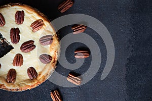 Cheesecake with pecan nuts on a black background