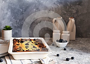 Cheesecake with ricotta on kitchen table on concrete background