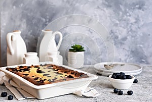 Cheesecake with ricotta on kitchen table on concrete background