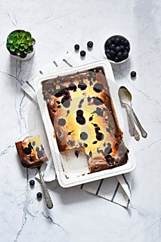 Cheesecake with ricotta on kitchen table on concrete background