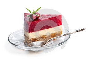 Cheesecake slice with jellied layer on top on glass plate isolated on white