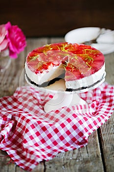 Cheesecake with strawberries in gelatine and herbs, on oreo cookies