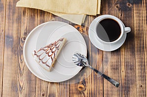 Cheesecake on a white plate with a cup of coffee