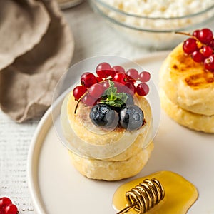 Cheesecakes decorated with fresh berries and honey on a plate. Food photos for dessert and Breakfast menus.