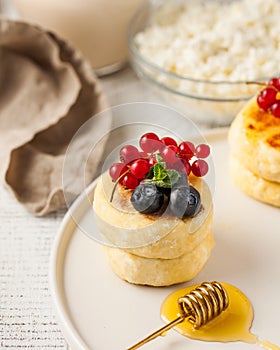 Cheesecakes decorated with fresh berries and honey on a plate. Food photos for dessert and Breakfast menus.
