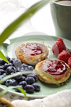 Cheesecakes with raspberry jam, berries, served with a cup of tea, cheesecakes