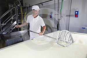 Cheesemaker breaks the curd