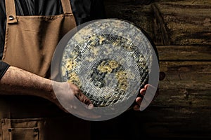 cheesemaker mele hands holding wheel hard cheese