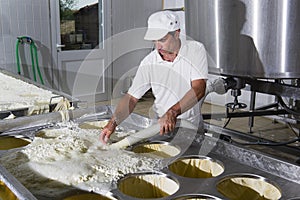 Cheesemaker pours cheese just curdled