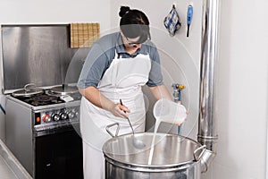 Cheesemaker pours the rennet