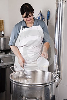 Cheesemaker pours rennet