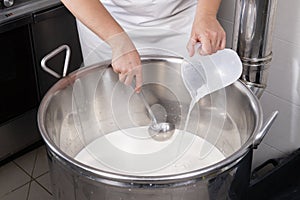 Cheesemaker pours rennet