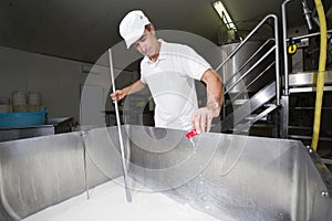 Cheesemaker pours rennet
