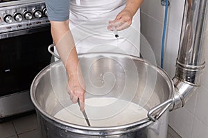 Cheesemaker pours the rennet with a syringe