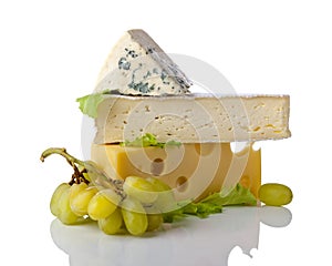 Cheeses and grapes with salad isolated on a white reflective ba