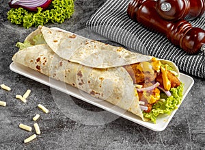 Cheesy Chicken shawarma Wrap served in a cutting board on grey background side view of fastfood