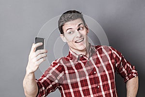Cheesy young athletic man enjoying taking selfie for seduction photo