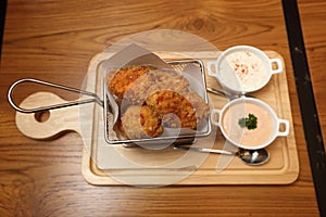 Cheeze Ball Chicken Wings in wire basket with Dip sauce on wooden plate table in restaurant photo
