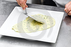 Chef add mashed potatoes on plate