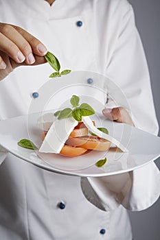 Chef adding greens to dish photo