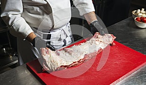 The chef also prepares lamb shank dishes. The process of cooking lamb shank male chef in a professional kitchen. Cooking