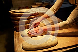 Chef or baker with dough cooking bread at bakery
