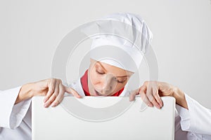 Chef or baker woman showing blank empty billboard sign.