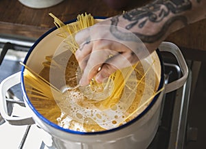 A chef boiling capellini pasta in the pot